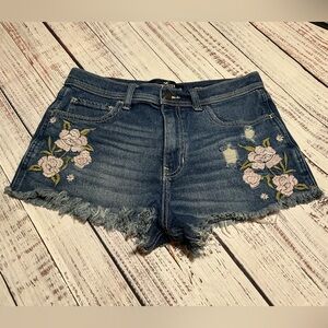 Hollister dark wash embroidered denim shorts with a frayed hem. Size 29.